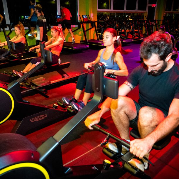 Gruppo di persone su vogatori durante allenamento cardio in palestra Ego Wellness.