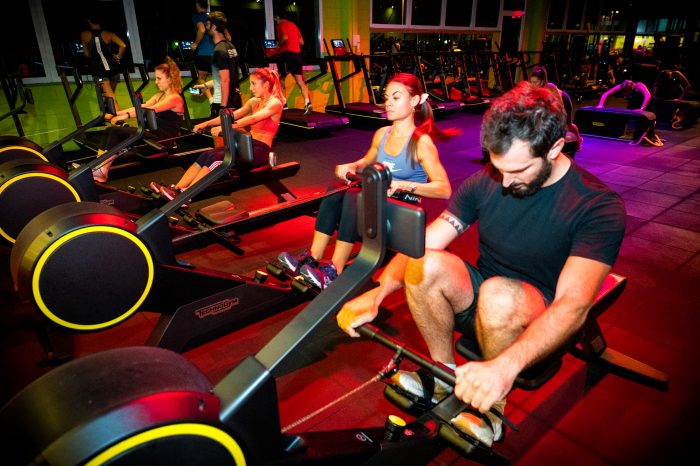 Gruppo di persone su vogatori durante allenamento cardio in palestra Ego Wellness.