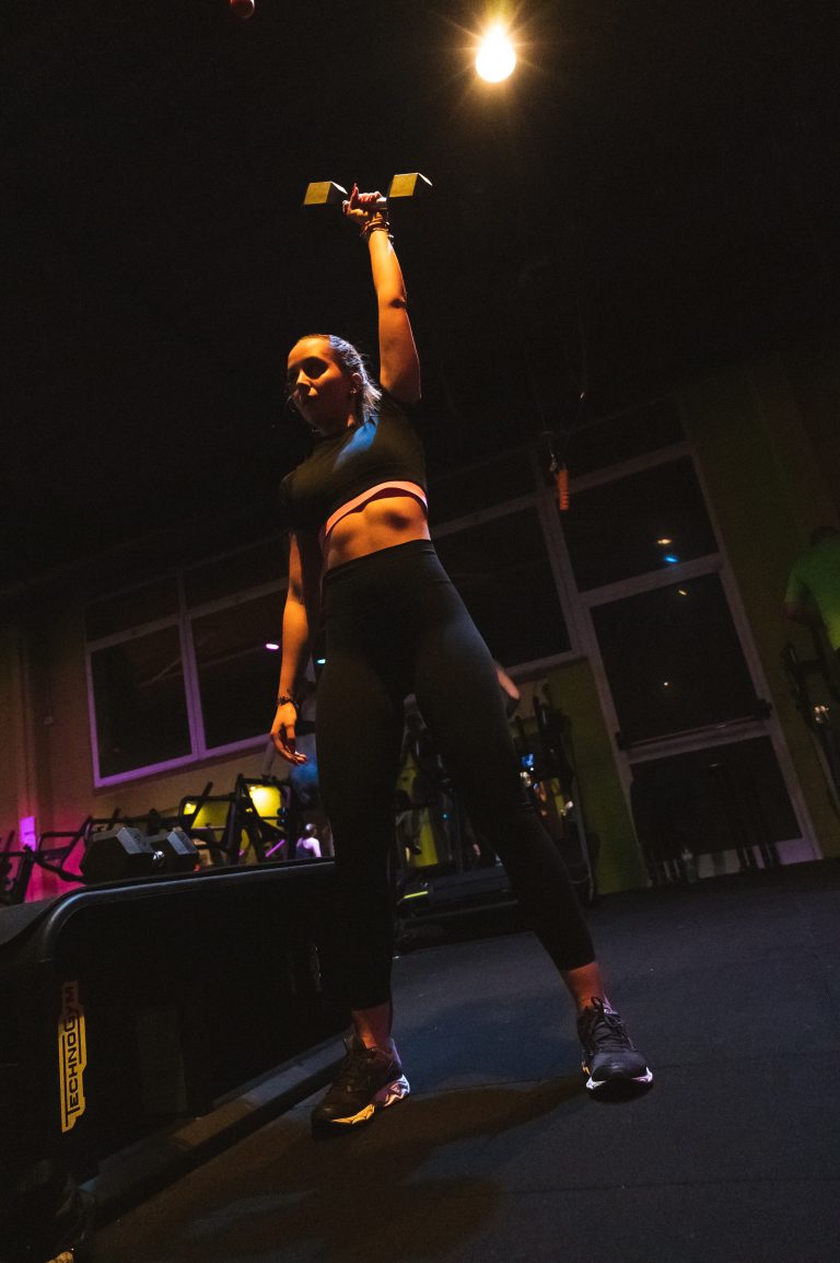 Donna che solleva un manubrio in palestra Ego Wellness.
