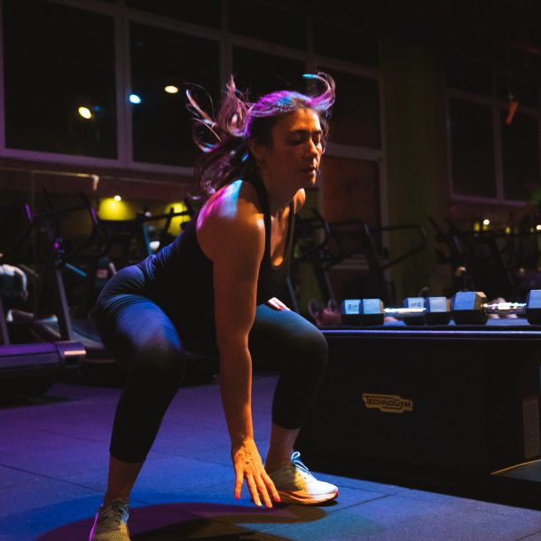 Donna che esegue esercizi di squat in palestra Ego Wellness.
