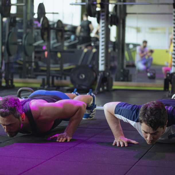 Due uomini eseguono push-up durante un allenamento funzionale in palestra presso Ego Wellness.