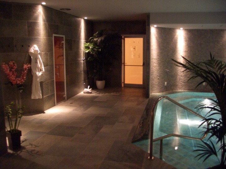 Area spa con piscina interna illuminata e ambiente rilassante.