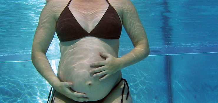 Donna durante una lezione di ginnastica in acqua per gestanti.
