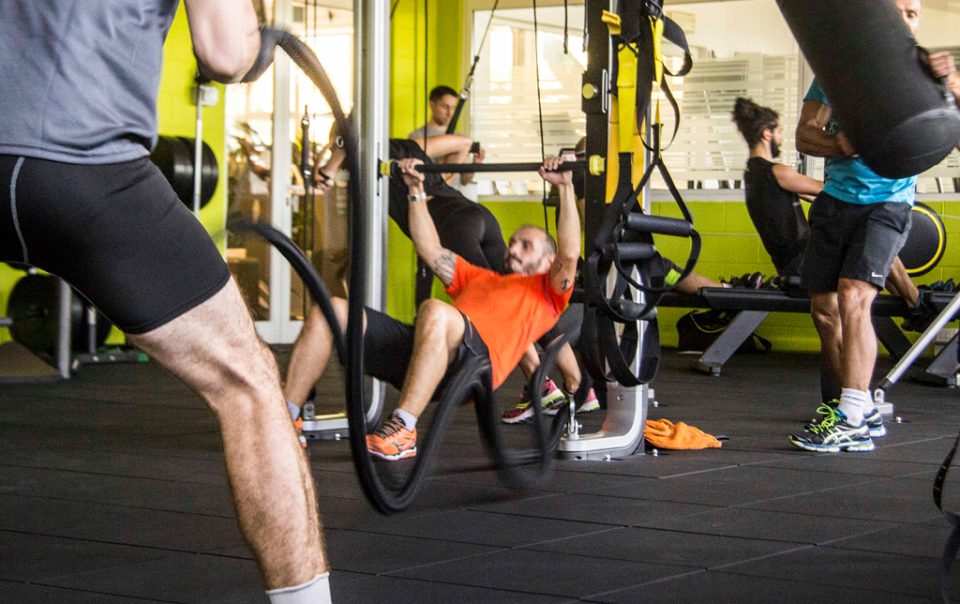 Gruppo di persone che si allenano con corde e attrezzi in palestra