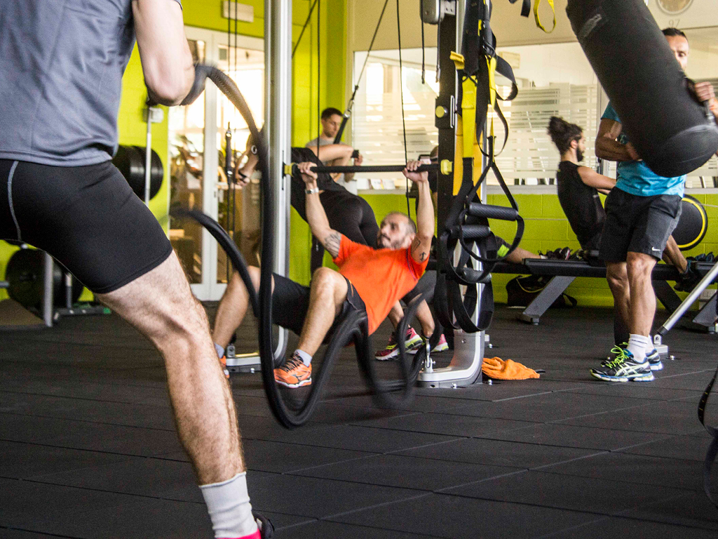 Gruppo di persone che si allenano con corde e attrezzi in palestra