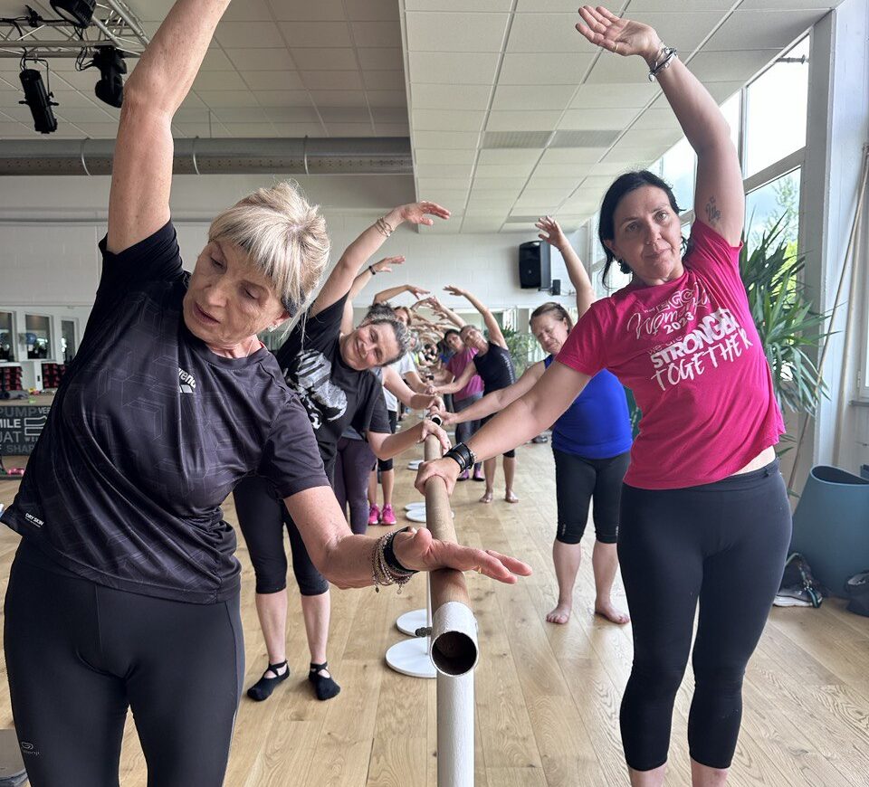 Classe di ginnastica alla sbarra per adulti, con esercizi di stretching.