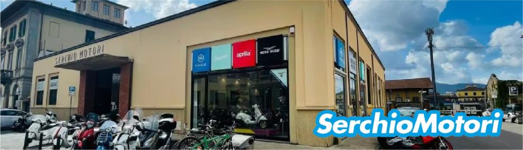 Esterno di Serchio Motori con scooter parcheggiati di fronte al negozio di moto a Lucca